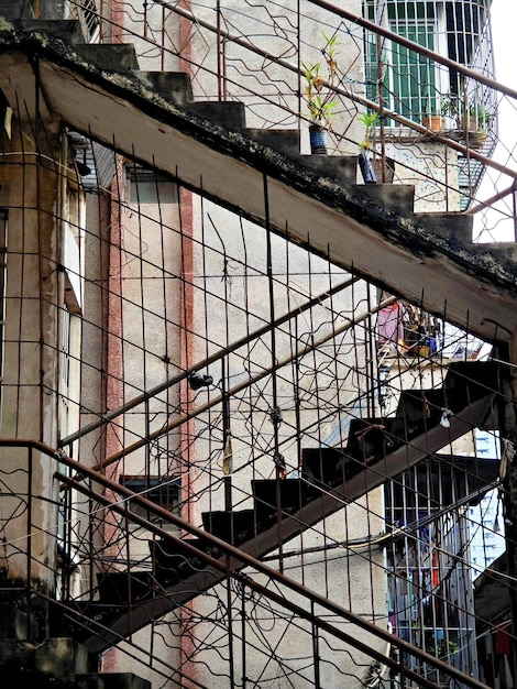 A staircase with a metal railing and a bunch of windows on the side.