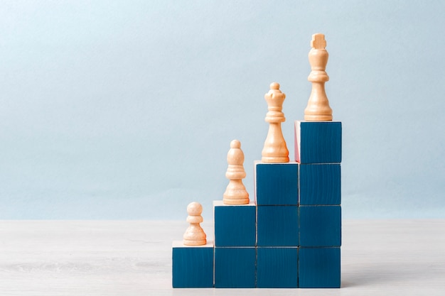 On the stairs of blue cubes are white chess pieces. Concept of career ladder, success
