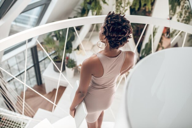 On the stairs. Dark-skinned young woman on the stairs