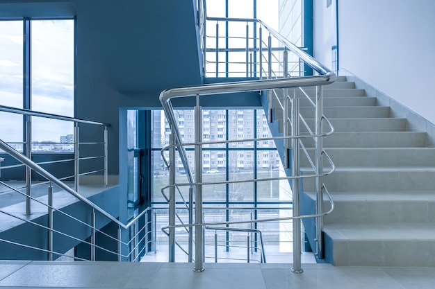 Stairs emergency and evacuation exit stair in up ladder in a new office building in blue color grading toning