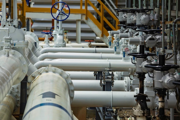 Stalen lange pijpen en pijpelleboog in de oliefabriek van het station tijdens de raffinaderij Petrochemie-industrie in gas