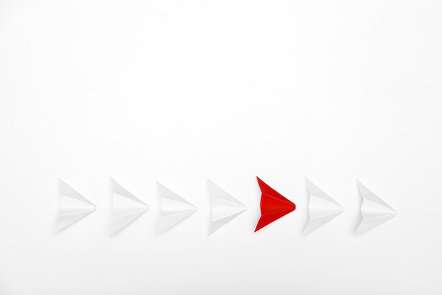 Stand out concept. Red paper airplane standing out from line of white 