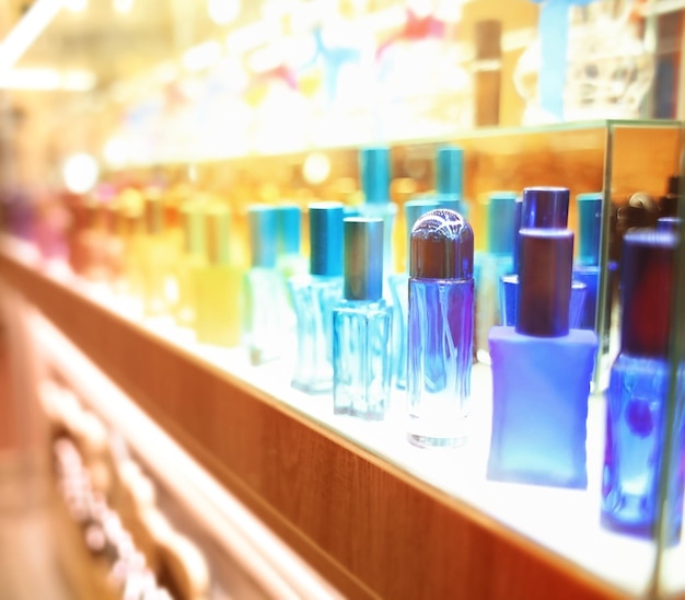 Photo stand with colourful glass bottles in cosmetic store