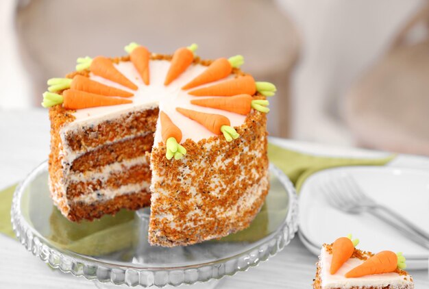 Stand with delicious sliced carrot cake on blurred background