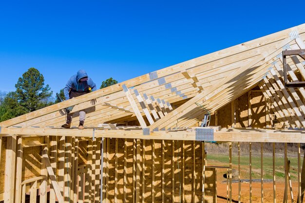 Foto standaard houtframe gebouw met close-up op het dak trusses arbeiders spijkers houten balken