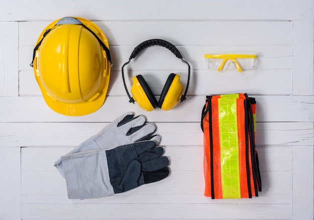 Standard construction safety equipment on white wooden background. 