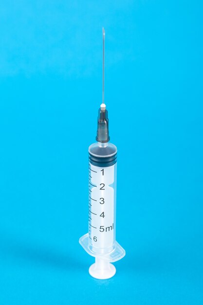 Standard design single use syringe isolated on blue.