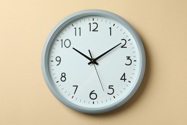 Standard gray home clock on beige surface