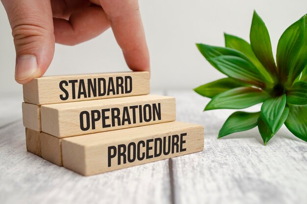 Standard operation procedure words on wooden blocks and hand