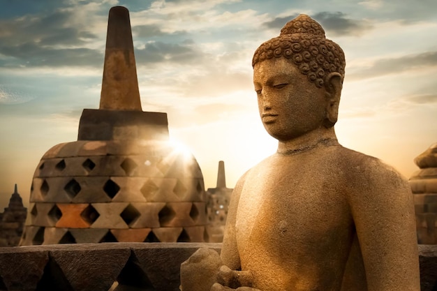 Standbeeld van Boeddha tegen de achtergrond van de zonsopgang met lichtstralen in de Borobudur-tempel Java-eiland Indonesië Beroemde historische plaats buiten religie concept