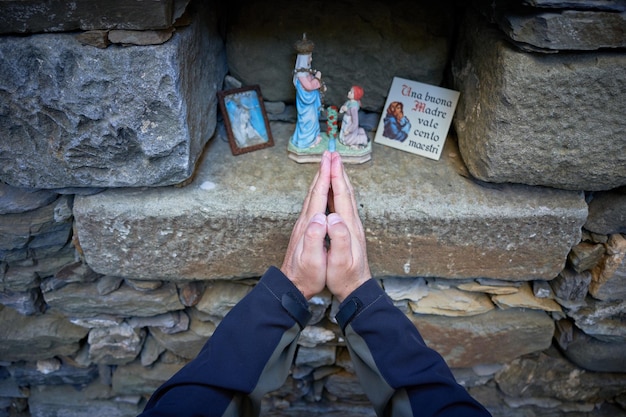 Standbeeld van de maagd maria in een zonsondergangscène in warme tinten, katholiek biddend voor onze lieve vrouw de maagd