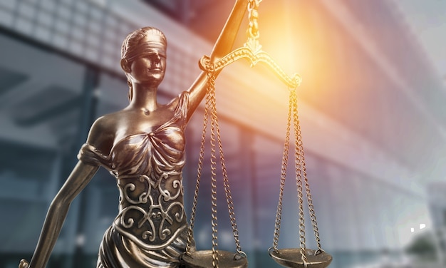Standbeeld van de Vrouwe van Justitie met schalen close-up op de achtergrond van het gerechtsgebouw