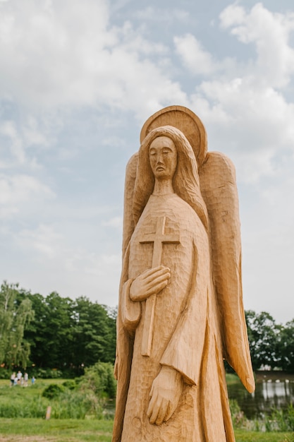Standbeeld van een engelenboom met vleugels en een kruis