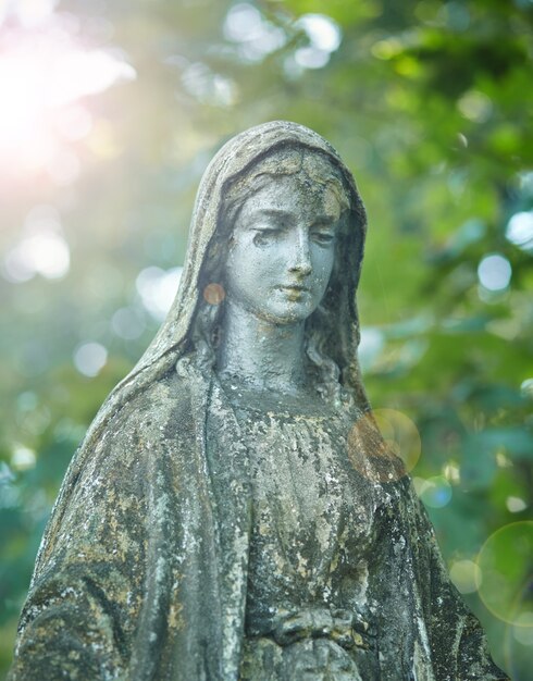 Standbeeld van maria moeder van god, op de herfstboom backgroung