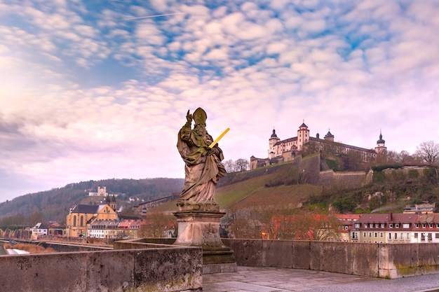 Standbeeld van Saint Kilian op de oude hoofdbrug, Alte Mainbrucke, met fort Marienberg op de achtergrond, Würzburg, Beieren, Duitsland