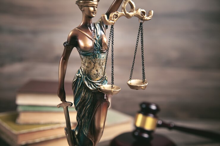 Foto standbeeld van vrouwe justitia, boek en hamer.