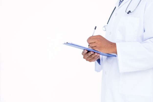 Standing doctor in white tunic writing notes