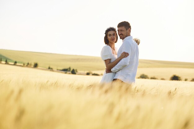 Standing and enjoying the nature Couple just married Together on the majestic agricultural field at sunny day