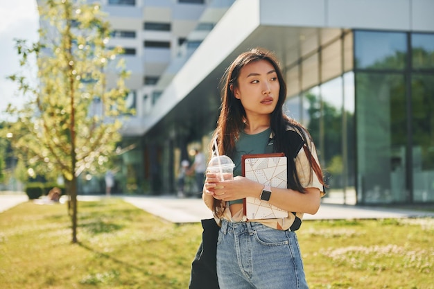 Photo standing on the grass young asian woman is outdoors at daytime