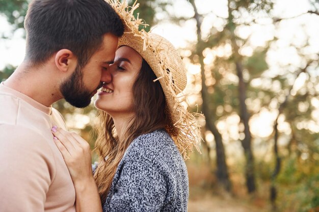 Standing and hugging Cheerful lovely young couple having a rest outdoors together