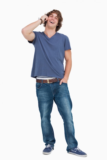 Standing male student laughing while calling