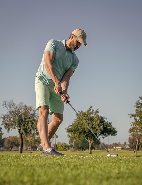 Standing man playing golf game on green grass golfing