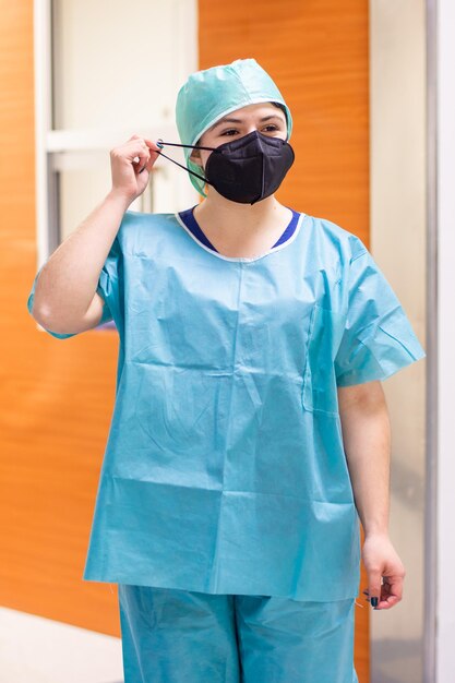 standing nurse removing her black mask