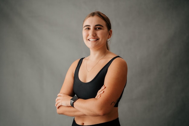 Photo standing smiling female with folded arms in her sports wear