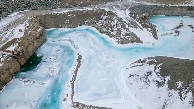 写真 岩石採石場の静止した水は採石場の中の峡谷の深くで青い影に凍り付きました
