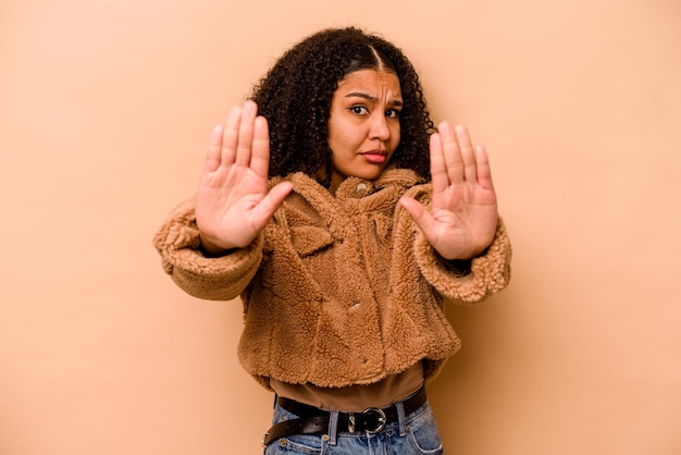 Standing with outstretched hand showing stop sign preventing you