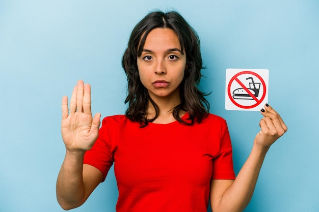 Standing with outstretched hand showing stop sign preventing you