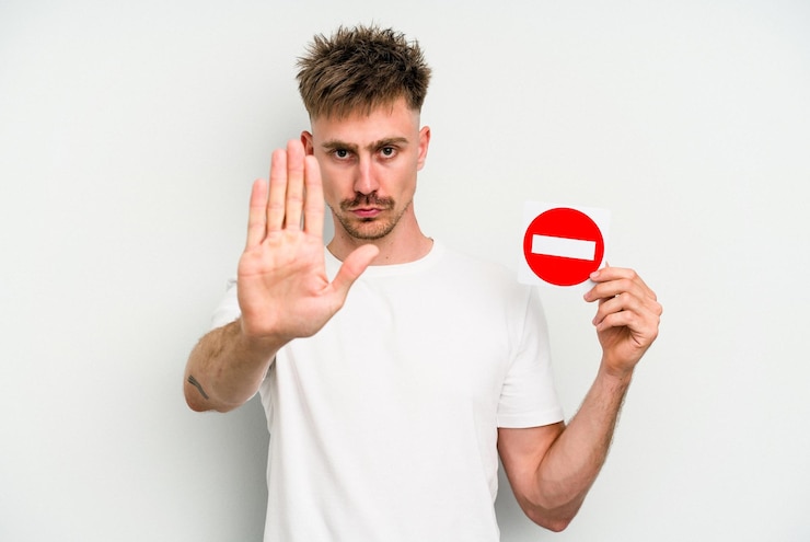 Photo standing with outstretched hand showing stop sign preventing you