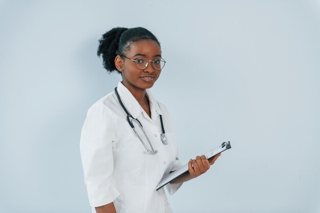 Photo standing with stethoscope young african american woman is against white background