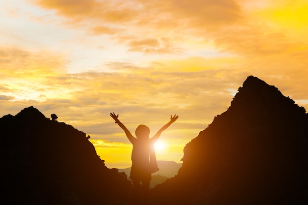 Standing woman holding hand evening sun and mountain silhouette girl stand