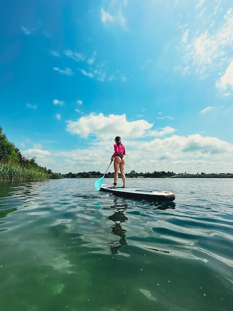 standing woman on supboard summer water lake activities