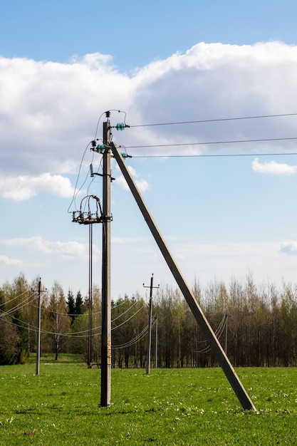 Foto stangen met elektrische draden in een groen veld