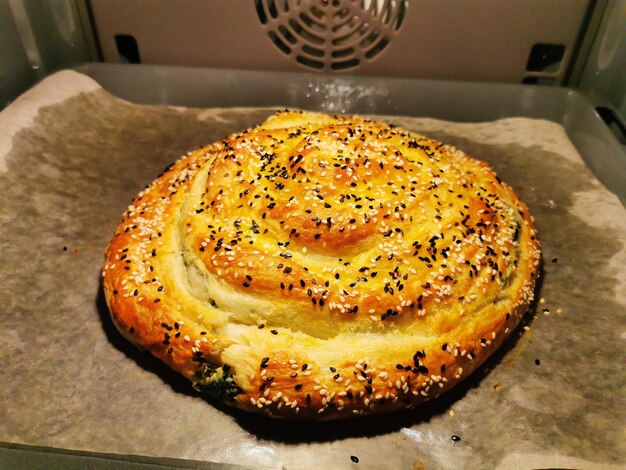 Foto stap 3 burek met spinazie en ricotta kaas ronde taart met kaaskruiden ingevet met dooier bestrooid met sesamzaad heerlijke balkantaart borek vegetarische bakwaren