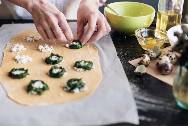 Stap voor stap bereidt de chef ravioli met ricotta kaas, dooiers kwarteleitjes en spinazie met kruiden. De chef bereidt de vulling op het deeg