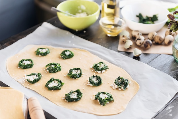 Stap voor stap bereidt de chef ravioli met ricotta kaas, dooiers kwarteleitjes en spinazie met kruiden. De chef bereidt de vulling op het deeg