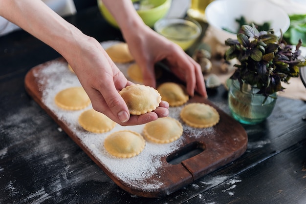 Stap voor stap bereidt de chef ravioli met ricotta kaas, dooiers kwarteleitjes en spinazie met kruiden. de chef bereidt zich voor om ravioli te koken