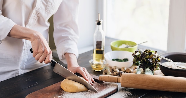 Stap voor stap bereidt de chef ravioli met ricotta kaas, dooiers kwarteleitjes en spinazie met kruiden. De chef werkt met het deeg