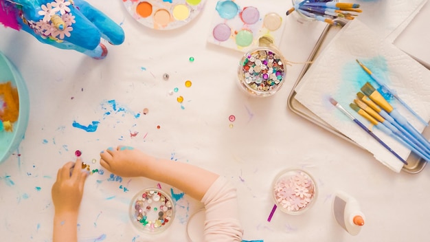 Stap voor stap. Beschilderde eenhoorn van papier-maché decoreren met papieren bloemen en juwelen.