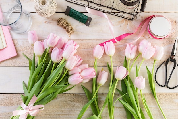 Stap voor stap. Bloemist die roze tulpen in boeket verpakken.