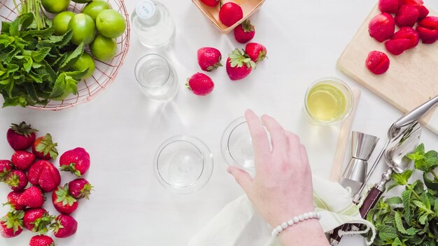 Stap voor stap. Fruit snijden voor aardbeienmojito van verse biologische aardbeien.