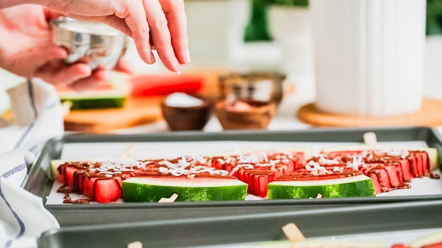 Stap voor stap. Garneer watermeloenijs met zeezout, amandelen en kokos.