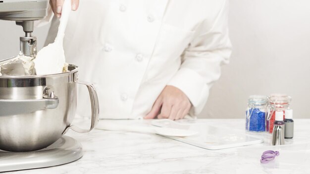 Stap voor stap. Het mengen van ingrediënten in een staande keukenmixer om buttercream frosting te maken.