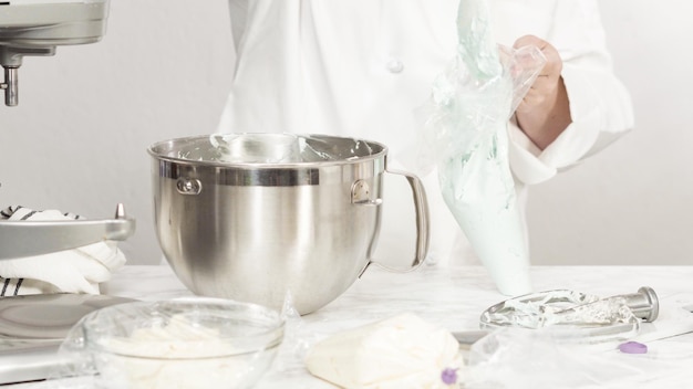 Stap voor stap. Het mengen van ingrediënten in een staande keukenmixer om buttercream frosting te maken.