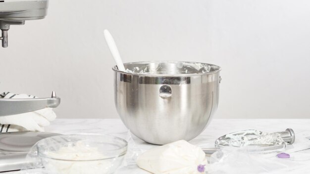 Stap voor stap. Het mengen van ingrediënten in een staande keukenmixer om buttercream frosting te maken.