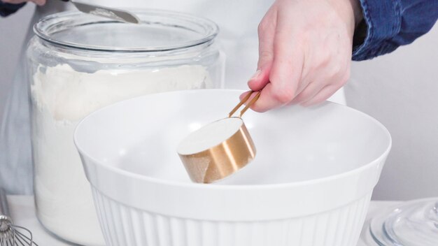 Stap voor stap. Ingrediënten mengen in een witte mengkom om eenhoorn-chocolade-cupcakes te maken met botercreme frosting.