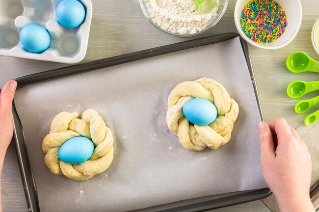 Stap voor stap. Italiaans paasbrood bakken met blauw gekleurd ei.